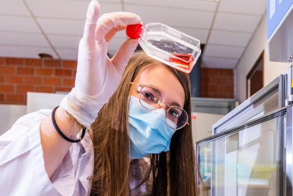 Une chercheuse tenant un flacon dans un laboratoire