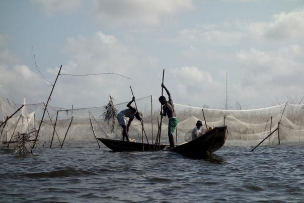 Des personnes pêchant sur une barque dans un pays du Sud