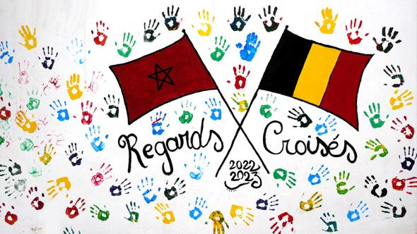 Deux drapeaux (Belgique et Maroc) croisés sur une toile blanche colorée de mains multicolores