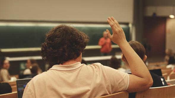 Etudiant qui lève la main pour poser une question