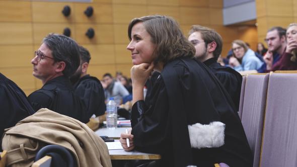 Femme avec une toge d'avocat au procès simulé du Fil rouge de droit