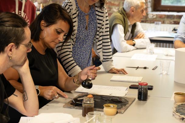 Participant qui écrit sur un parchemin - Colloque-atelier parchemins et enluminures UNamur (2024)
