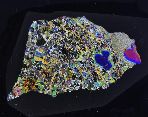 La météorite Erg Chech 002, la roche magmatique la plus ancienne du système solaire (4,5 milliards d’années), vue au microscope polarisant (4 cm de long)