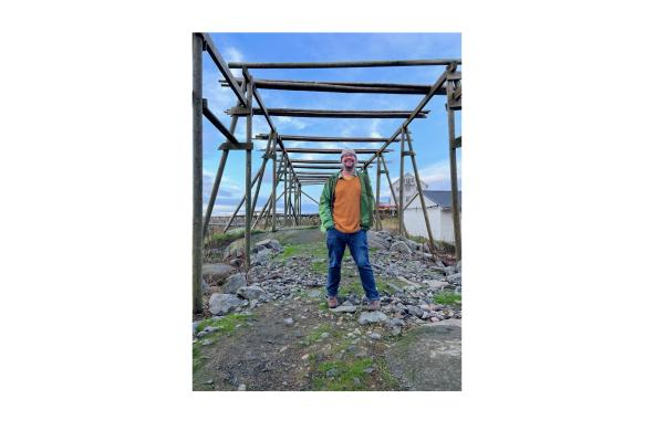 Brendan Reid dans les îles Lofoten, en Norvège, avec des séchoirs utilisés dans la pêche norvégienne à la morue - l'un des d'étude dans laquelle les chercheurs ont utilisé des échantillons de 1907 associés à des échantillons des années 2010 afin de comprendre comment la morue s'est adaptée à la surpêche.  © Patrice Escandon
