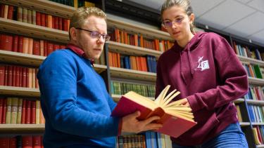 Etudiante et professeur dans une bibliothèque
