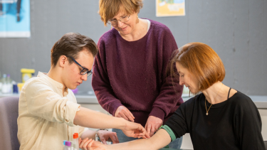 Etudiant en médecine générale réalisant une prise de sang sous supervision