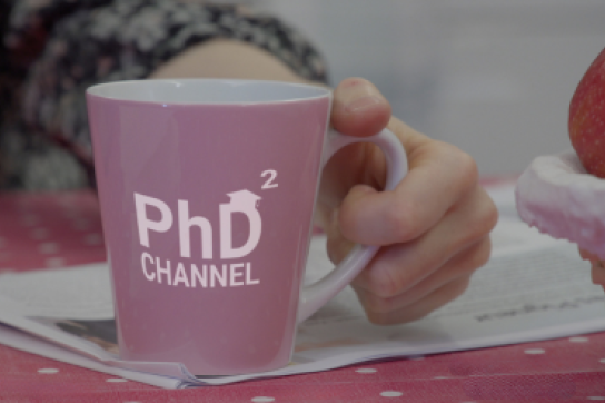Personne tenant une tasse avec la mention PhD Channel