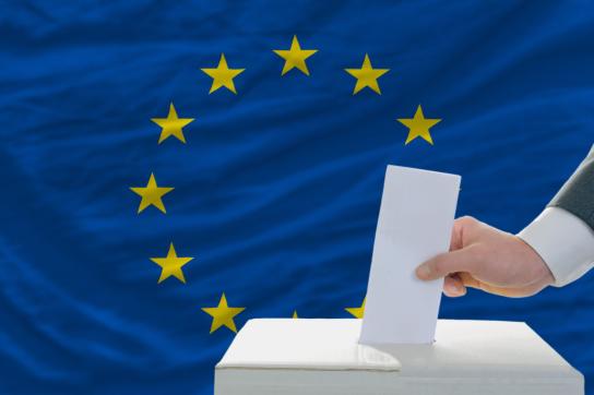 Une urne avec un drapeau européen en fond d'image